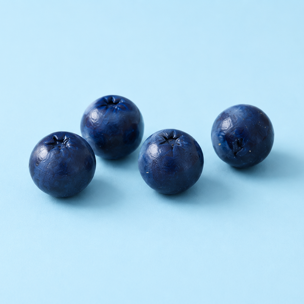 Five blueberries on a light blue background